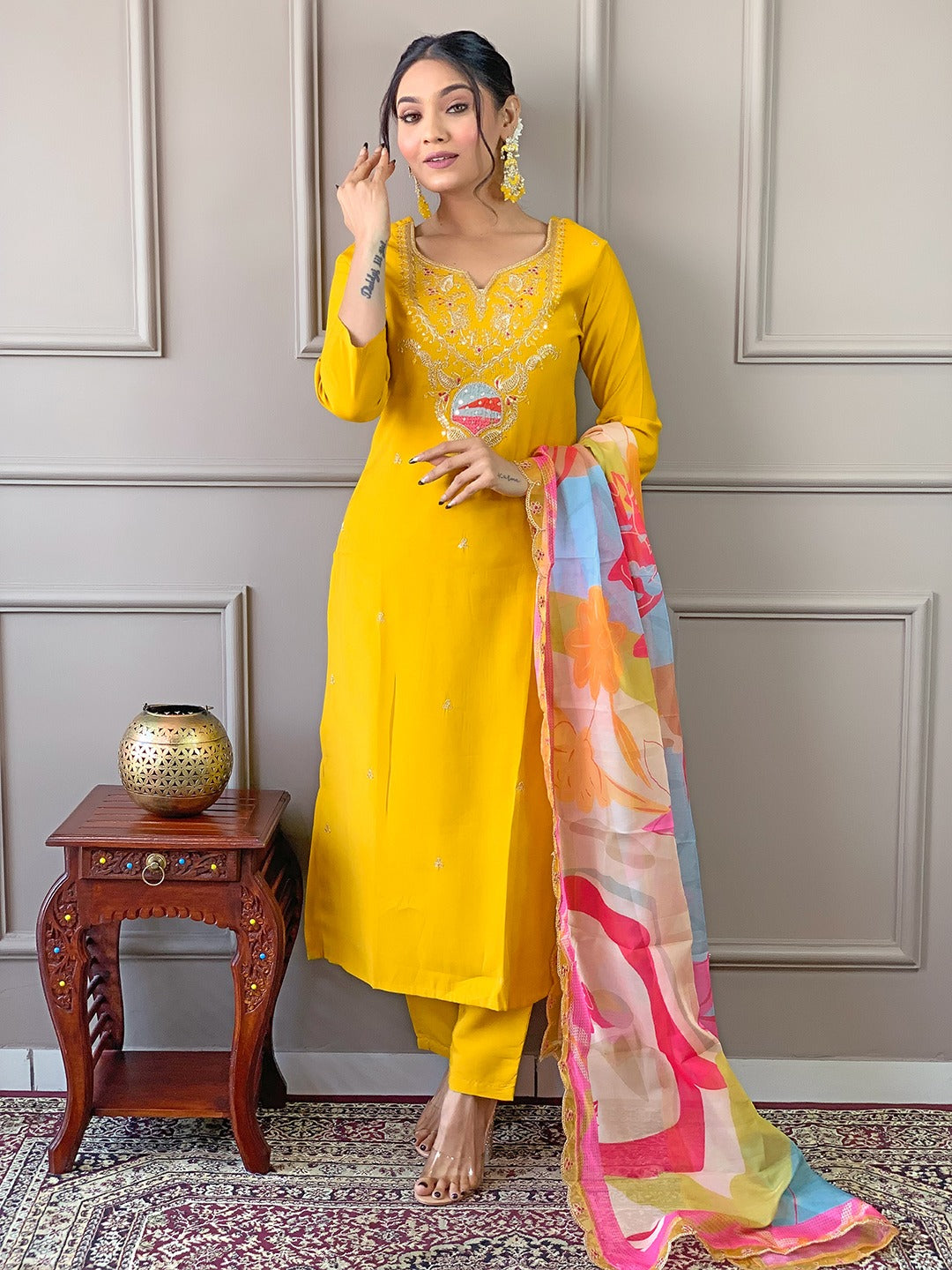 Brighten up your wardrobe with this radiant yellow kurti set, featuring delicate embroidery and a vibrant multicolored dupatta