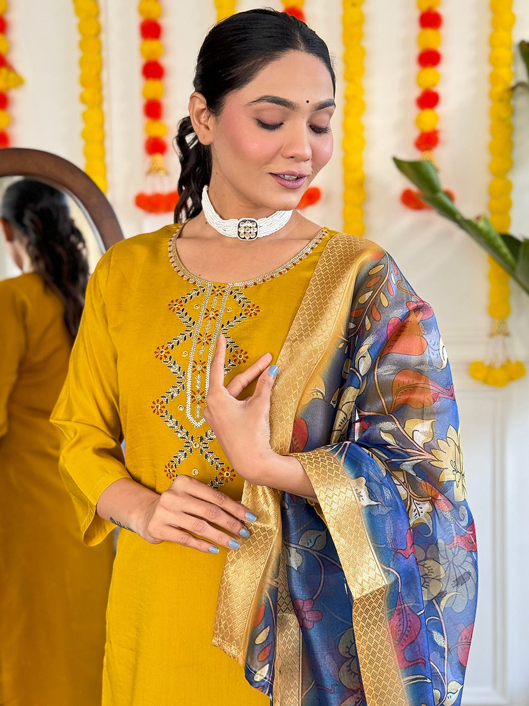 Embrace timeless elegance with this mustard yellow kurti set, featuring delicate embroidery and a regal blue floral dupatta