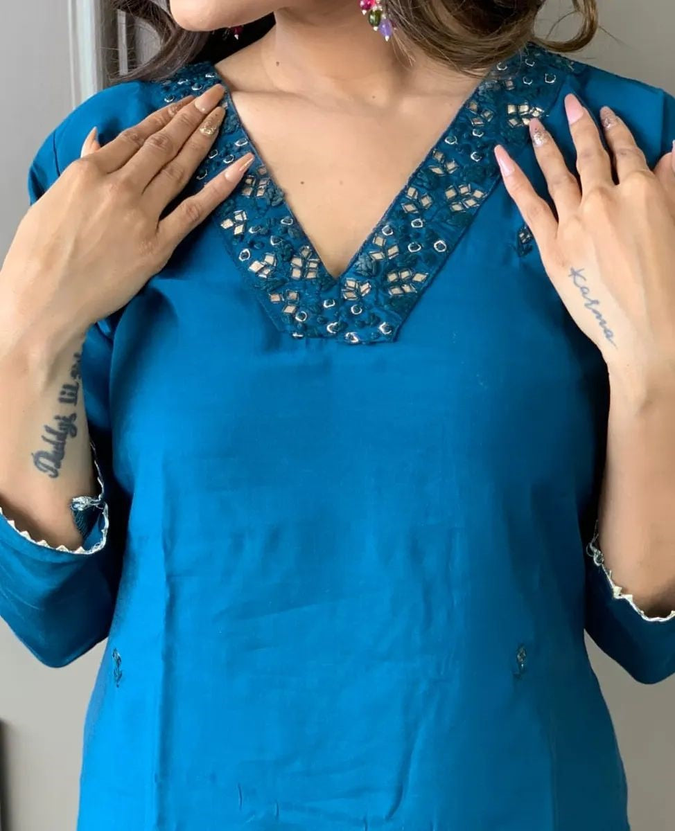 Elevate your style with this elegant blue kurti set, featuring intricate embellishments and a vibrant pink and blue zigzag dupatta