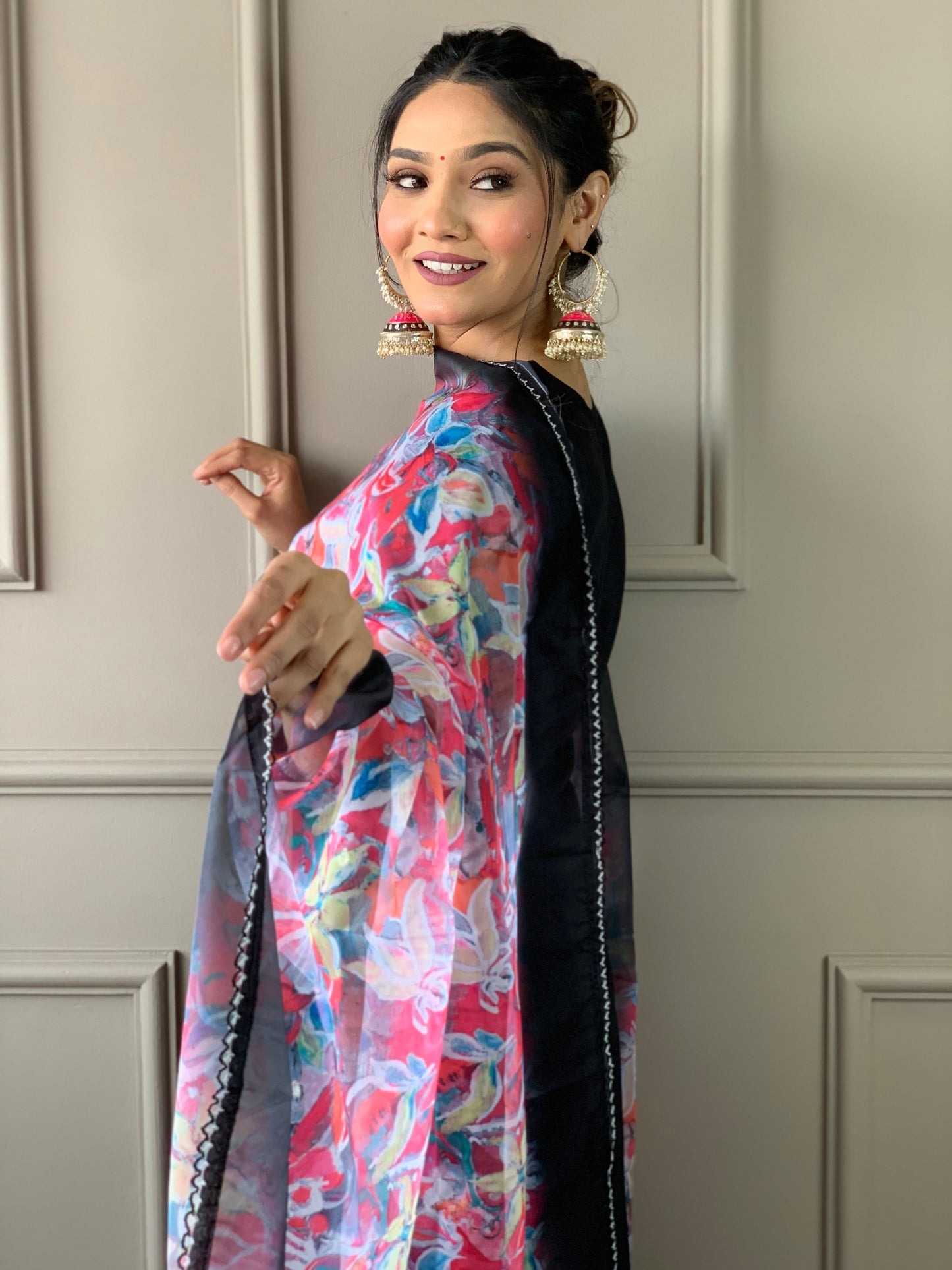 Make a statement with this elegant black kurta set, featuring delicate pearl embellishments and a striking floral dupatta