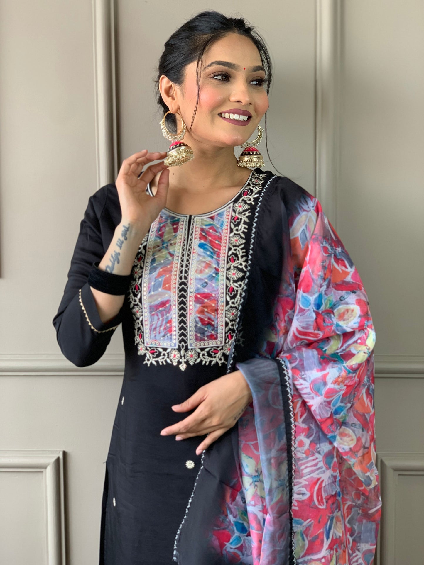 Make a statement with this elegant black kurta set, featuring delicate pearl embellishments and a striking floral dupatta