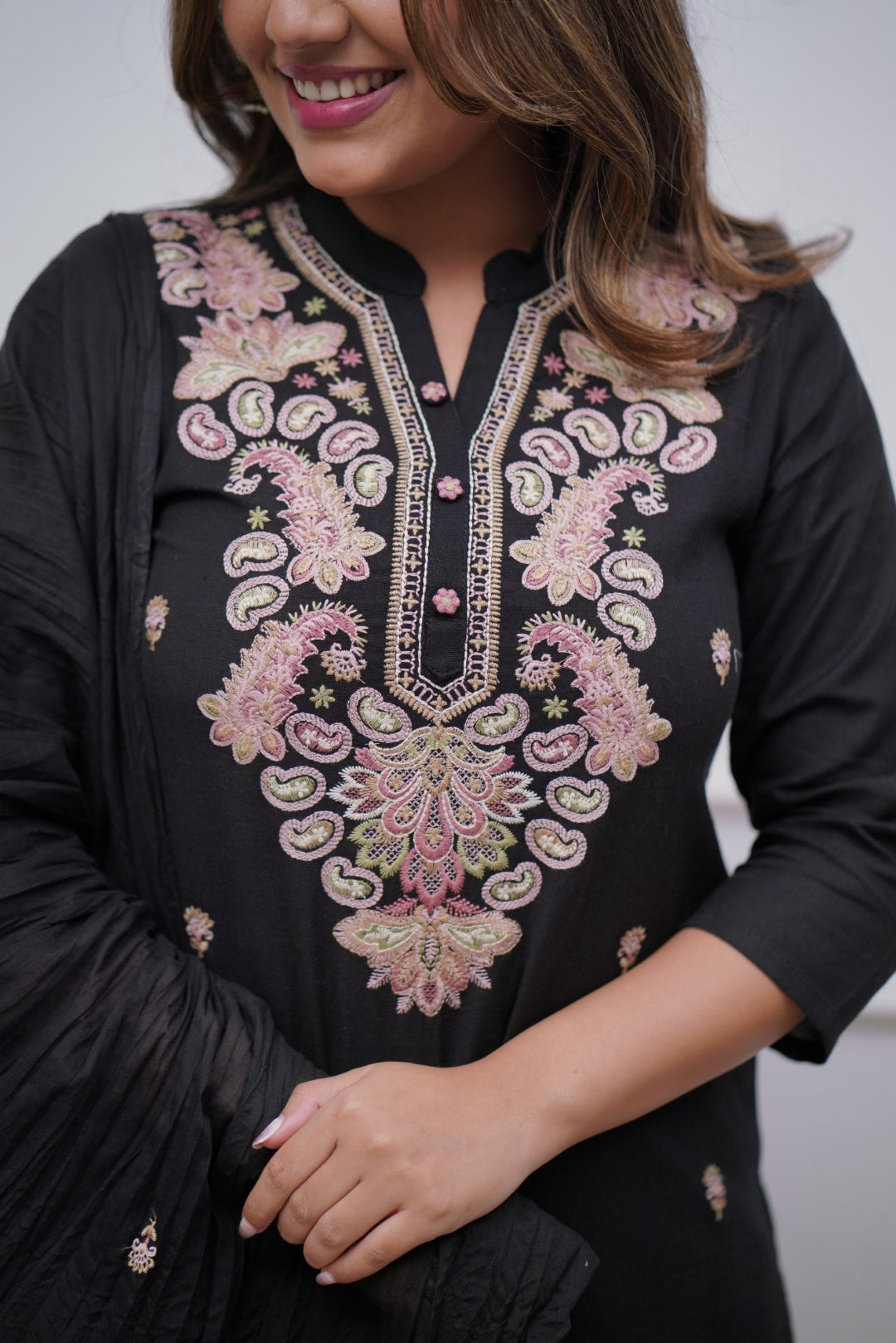 Make a bold statement with this classic black kurti set, featuring intricate pastel embroidery and a matching dupatta