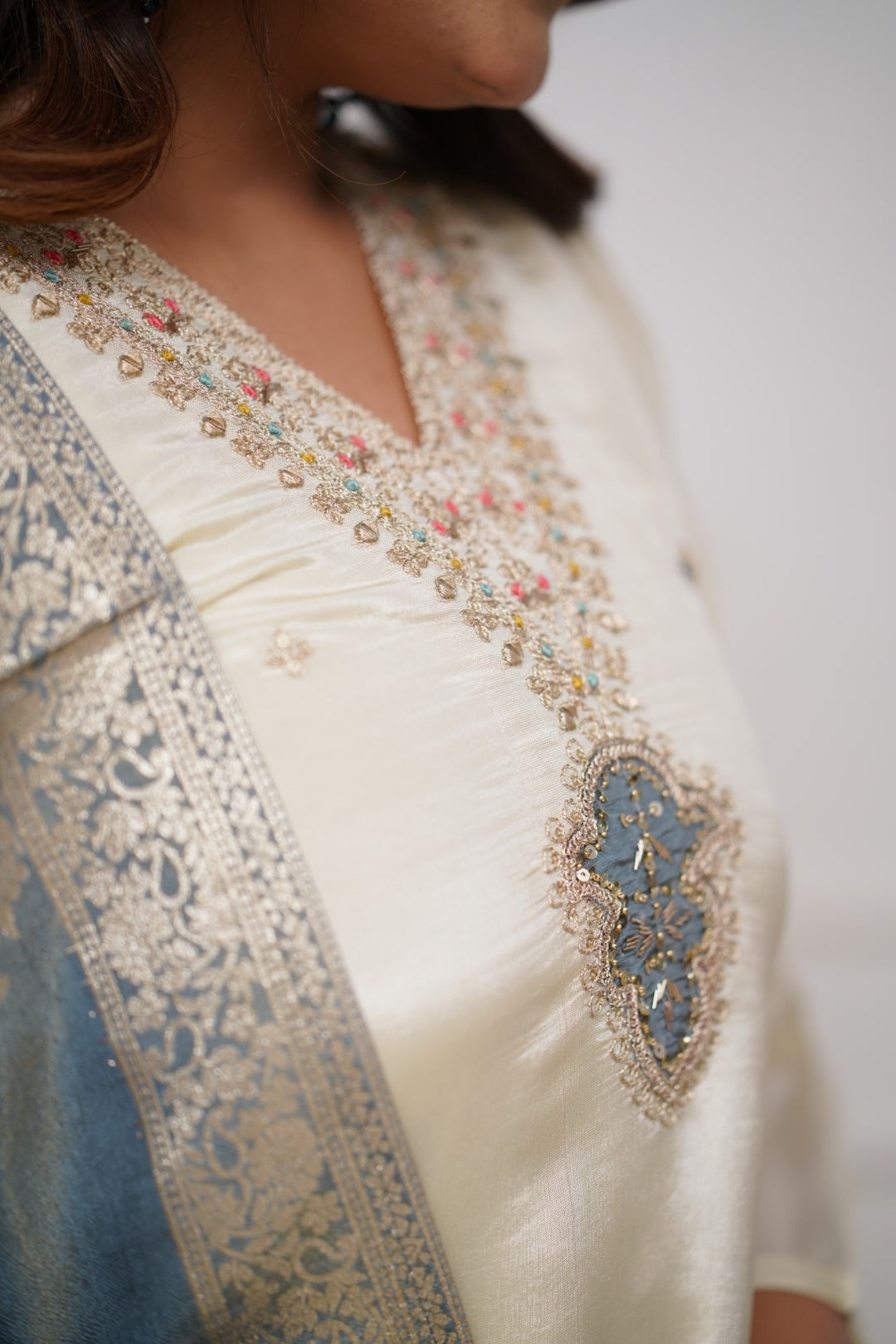 Embrace timeless elegance with this ivory kurti set, featuring delicate embellishments and a regal blue dupatta with intricate gold detailing