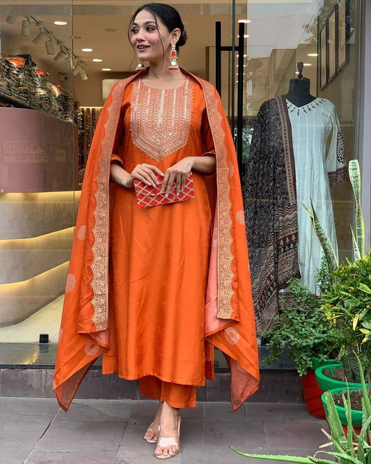 This vibrant orange kurti set exudes elegance with intricate embroidery and a luxurious dupatta featuring delicate border detailing