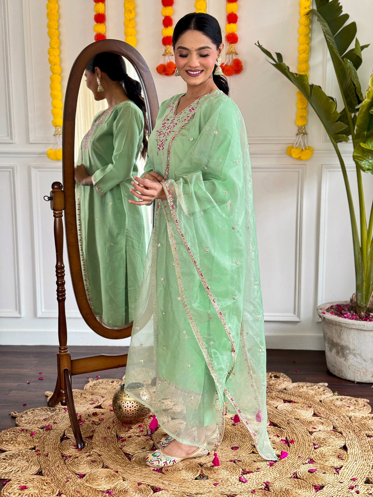 Step into elegance with this pastel green kurti set, adorned with delicate pink floral embroidery and shimmering accents