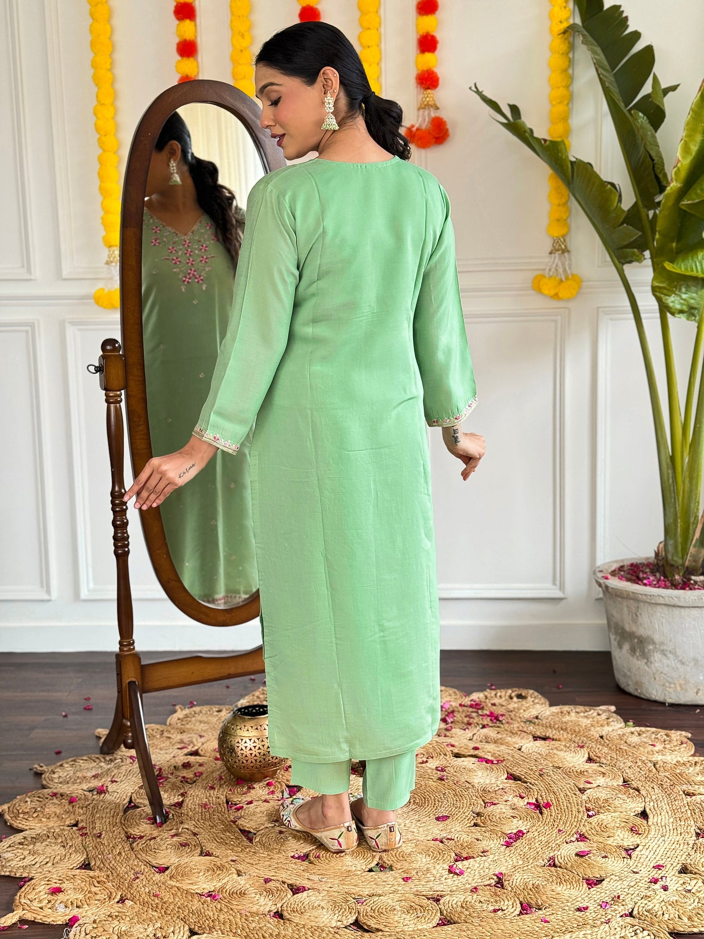 Step into elegance with this pastel green kurti set, adorned with delicate pink floral embroidery and shimmering accents