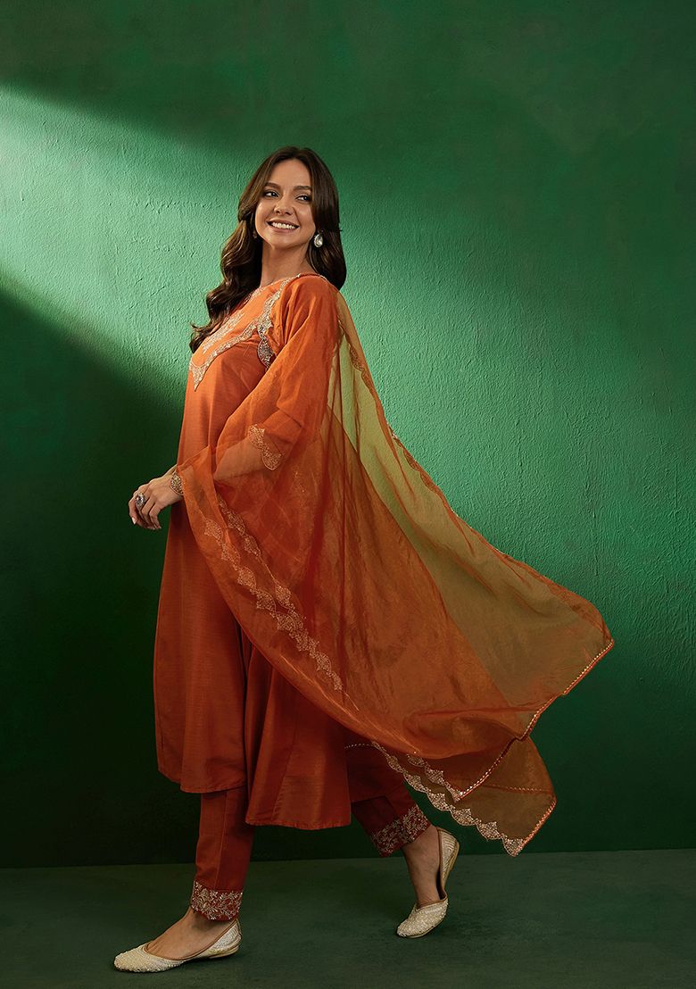 Radiate elegance in this rust-orange kurti set, adorned with intricate embroidery and a sheer embellished dupatta