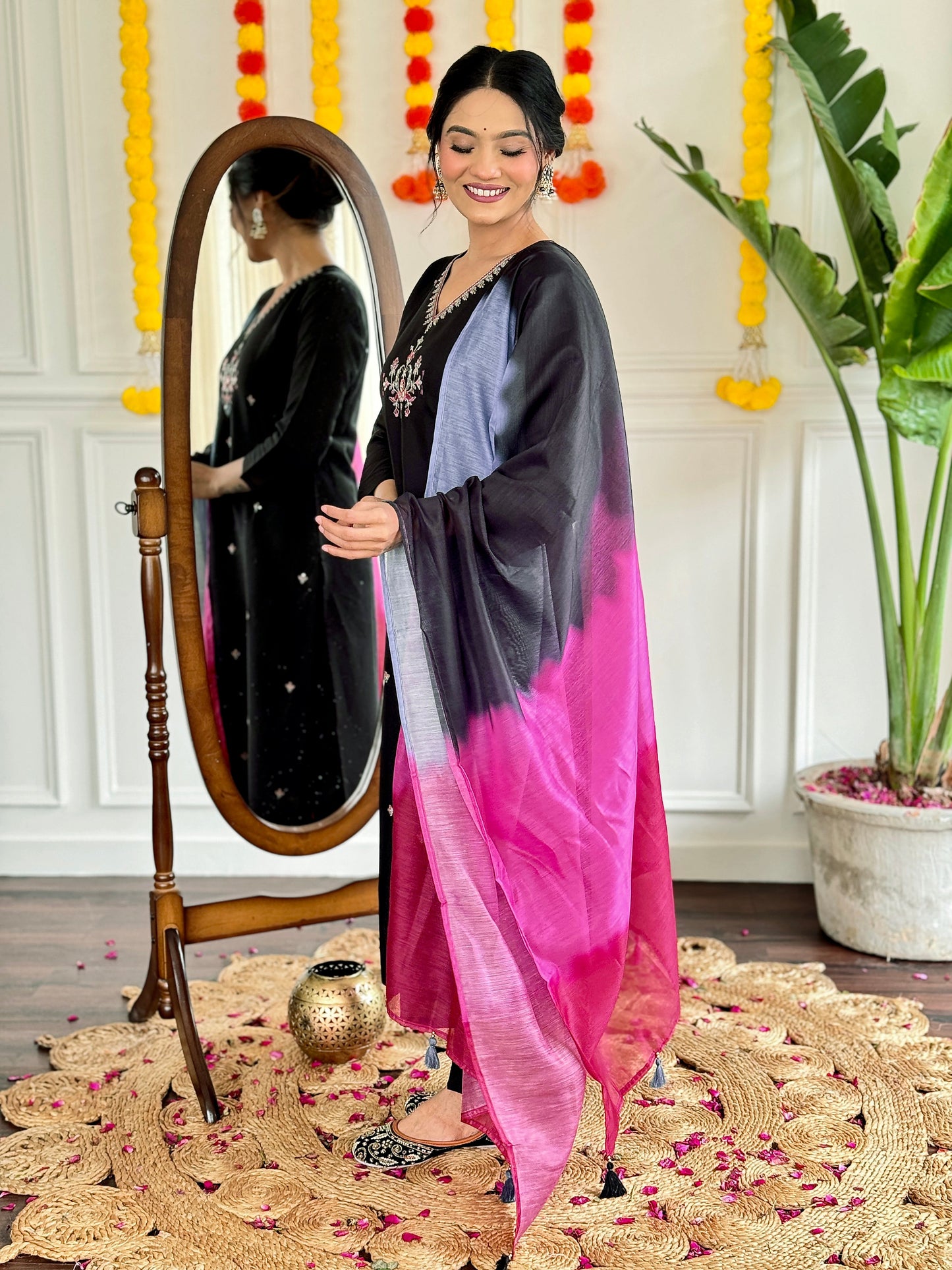 Make a bold statement with this stunning black kurti set, featuring intricate embroidery and a striking ombre dupatta in shades of pink and grey
