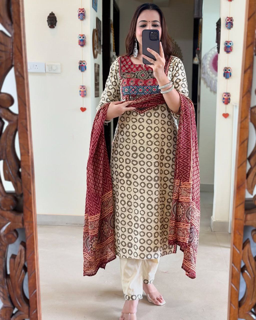 Elevate your ethnic wardrobe with this elegant beige kurti set featuring intricate Ajrakh embroidery on the yoke and sleeves. Paired with matching straight pants and a rich red dupatta, it offers timeless grace for festive and casual wear alike