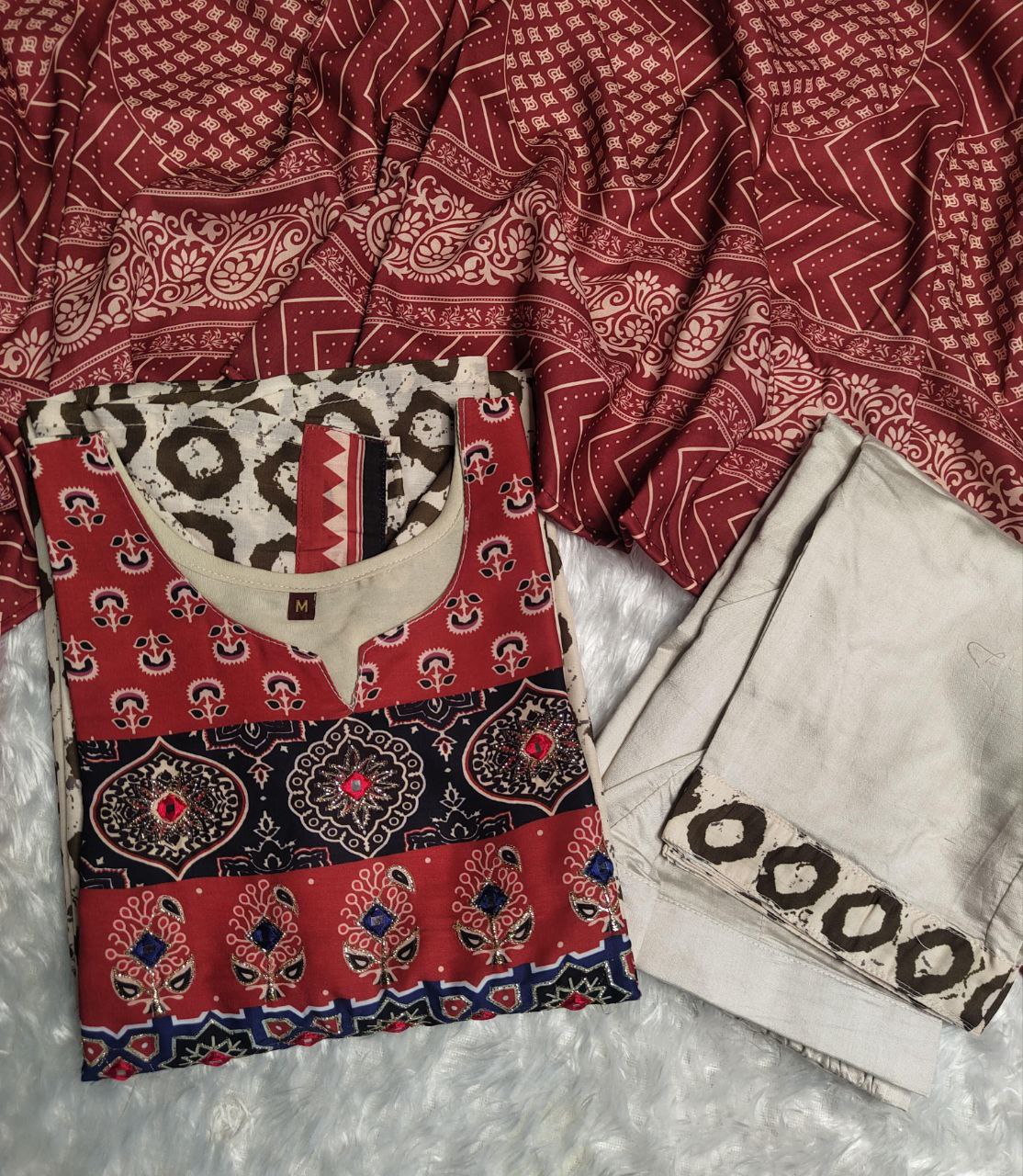 Elevate your ethnic wardrobe with this elegant beige kurti set featuring intricate Ajrakh embroidery on the yoke and sleeves. Paired with matching straight pants and a rich red dupatta, it offers timeless grace for festive and casual wear alike