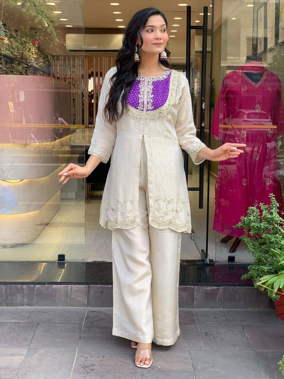 Elevate your ethnic style with this elegant cream kurti set featuring intricate embroidery and a striking purple yoke. Paired with flared pants, this outfit blends tradition with modern flair—perfect for festive occasions or graceful daywear.