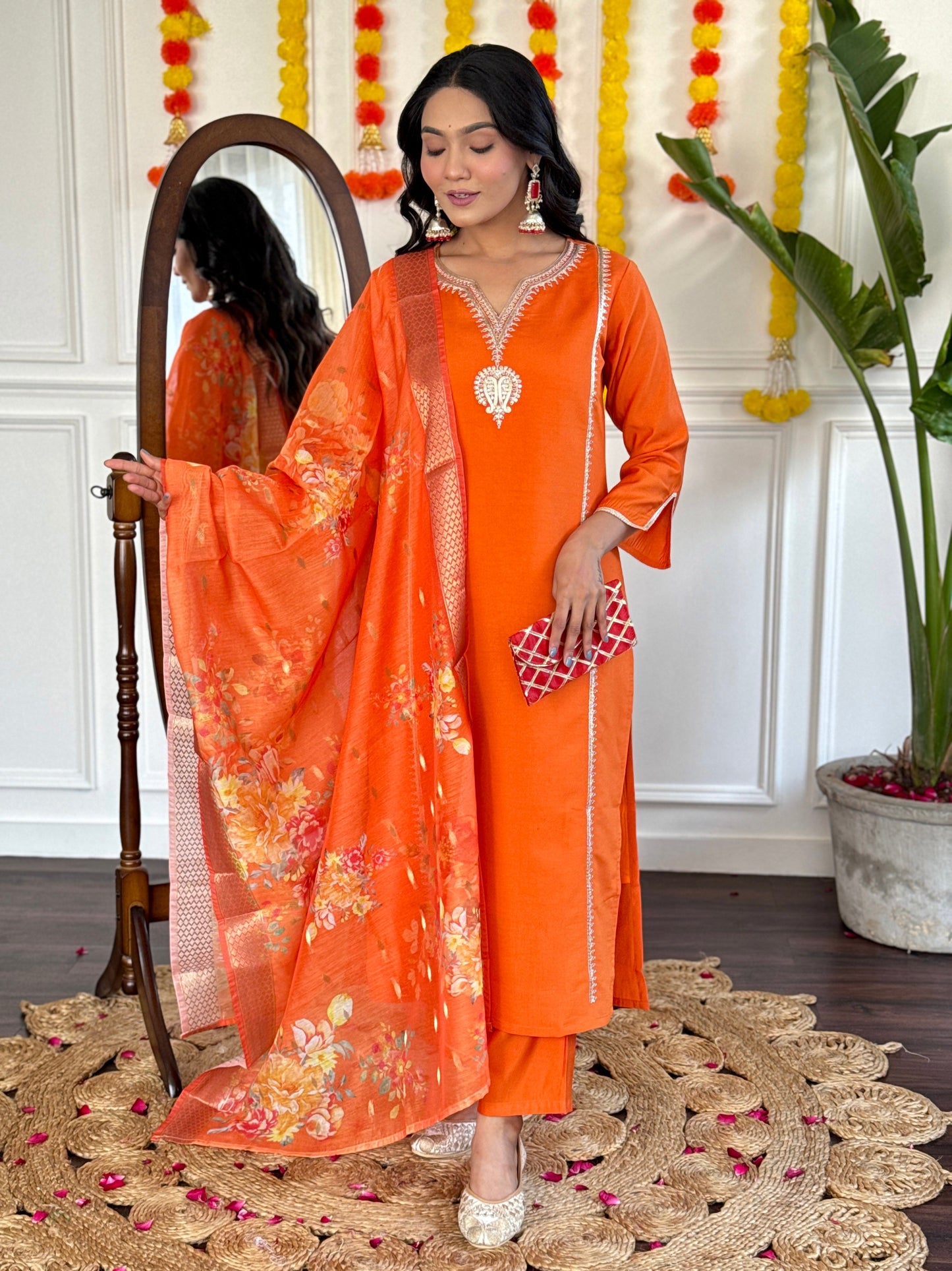 Radiate festive charm in this vibrant orange kurta set, adorned with delicate embroidery and a stunning floral dupatta