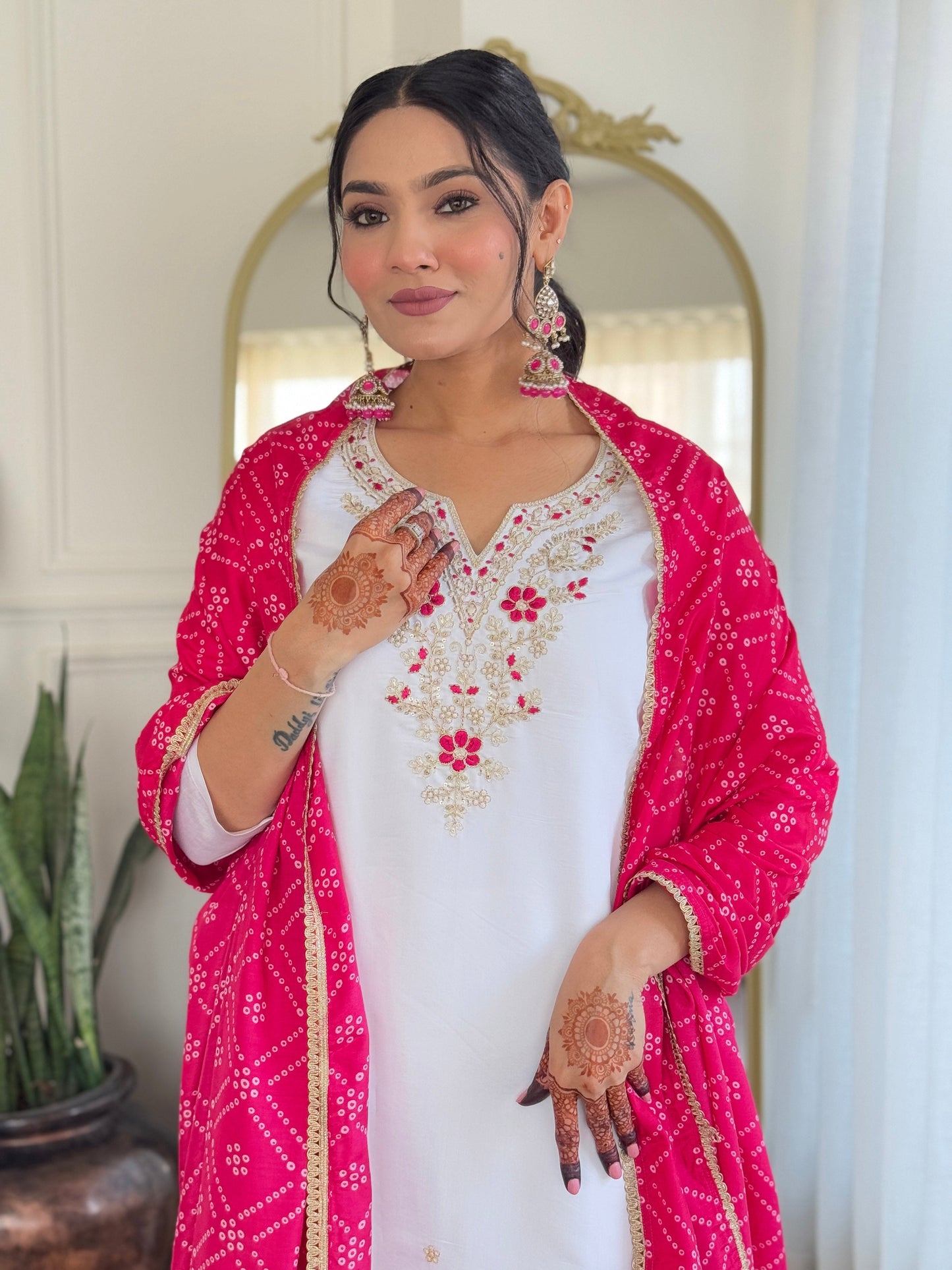 Elevate your elegance with this stunning white kurti set, adorned with intricate embroidery and paired with a vibrant pink bandhani dupatta