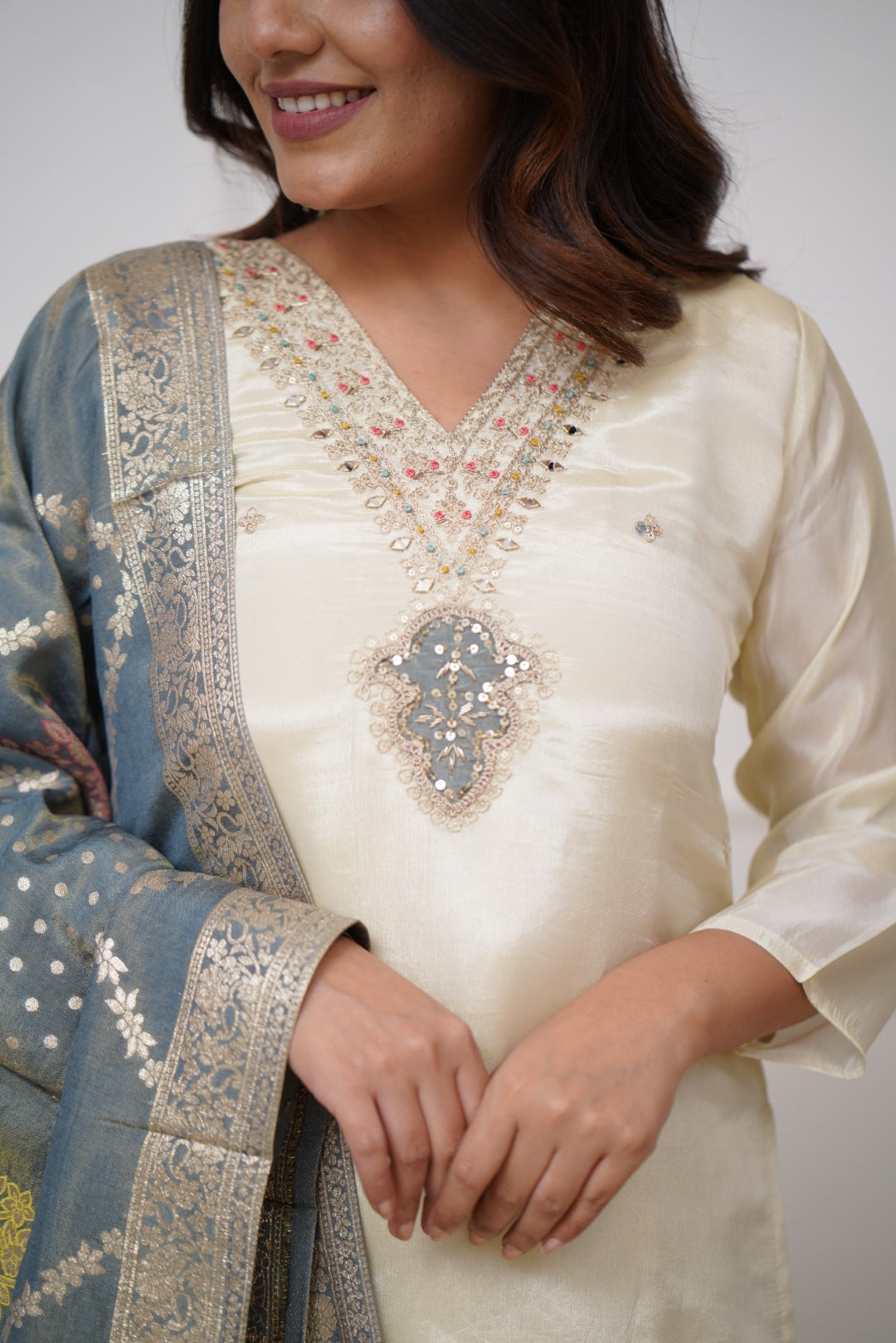 Embrace timeless elegance with this ivory kurti set, featuring delicate embellishments and a regal blue dupatta with intricate gold detailing