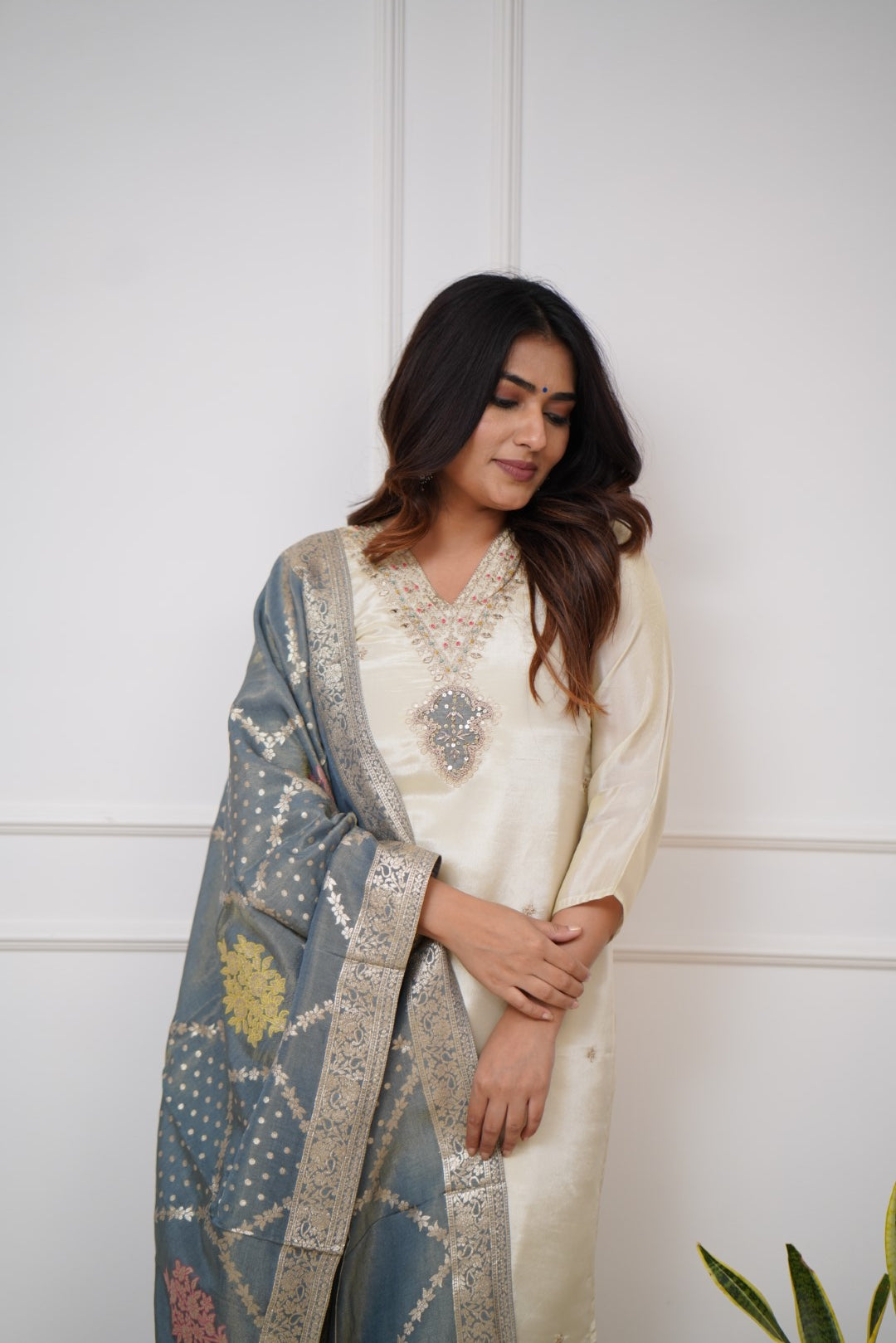 Embrace timeless elegance with this ivory kurti set, featuring delicate embellishments and a regal blue dupatta with intricate gold detailing