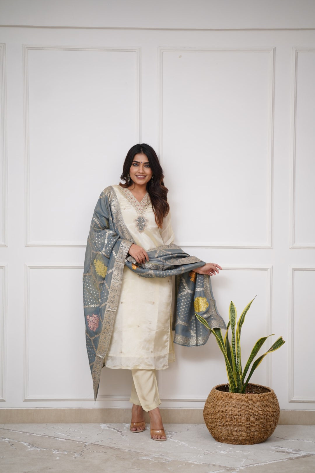 Embrace timeless elegance with this ivory kurti set, featuring delicate embellishments and a regal blue dupatta with intricate gold detailing