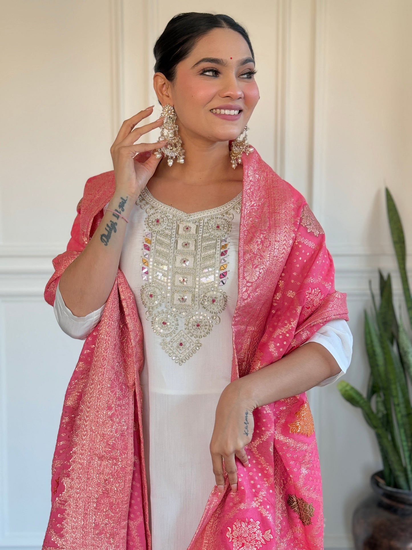 Grace meets tradition in this stunning white kurti set, highlighted with intricate embroidery and a vibrant pink Banarasi dupatta