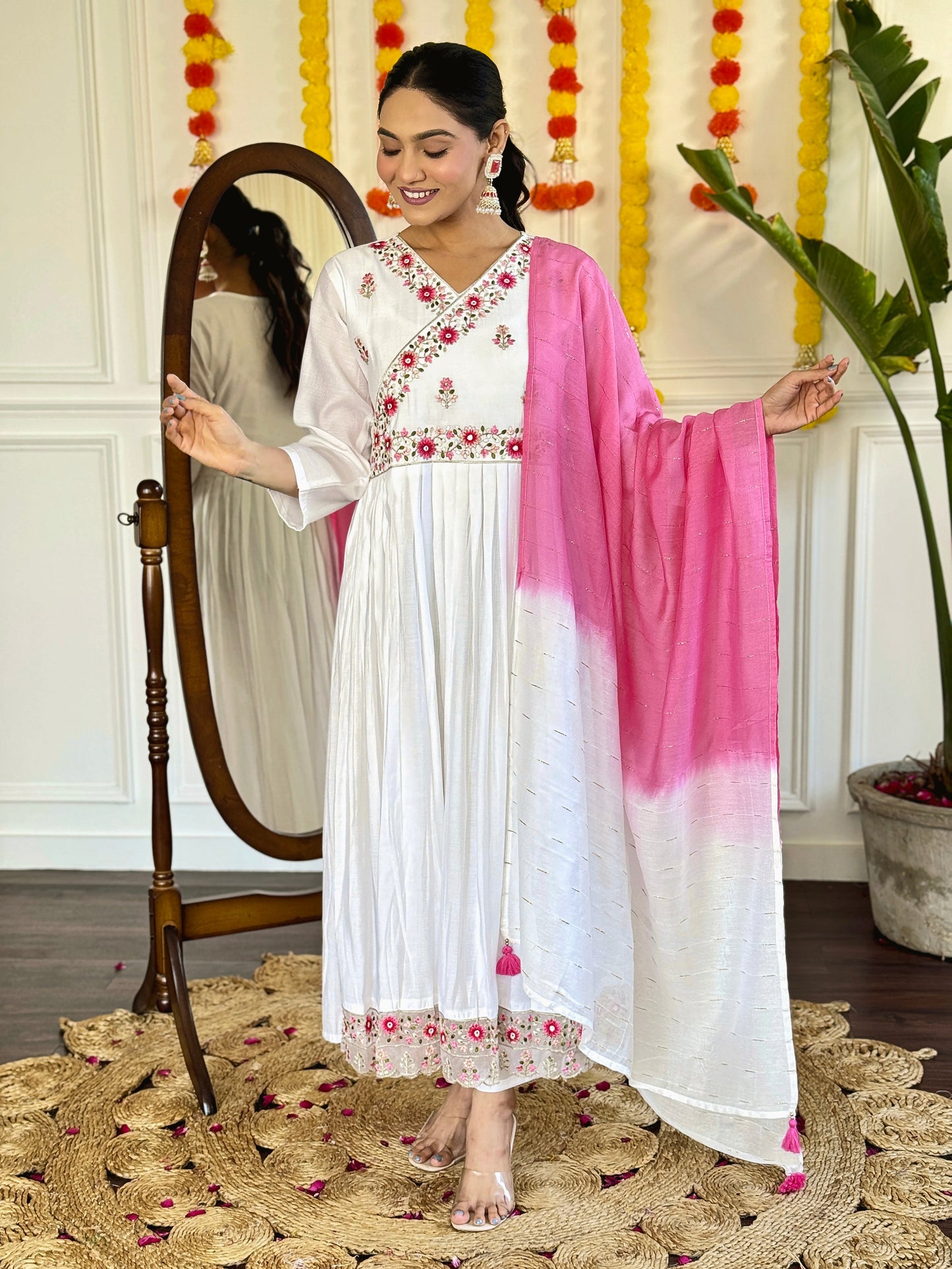Grace meets elegance in this ethereal white Anarkali set, adorned with delicate floral embroidery and a stunning pink ombre dupatta