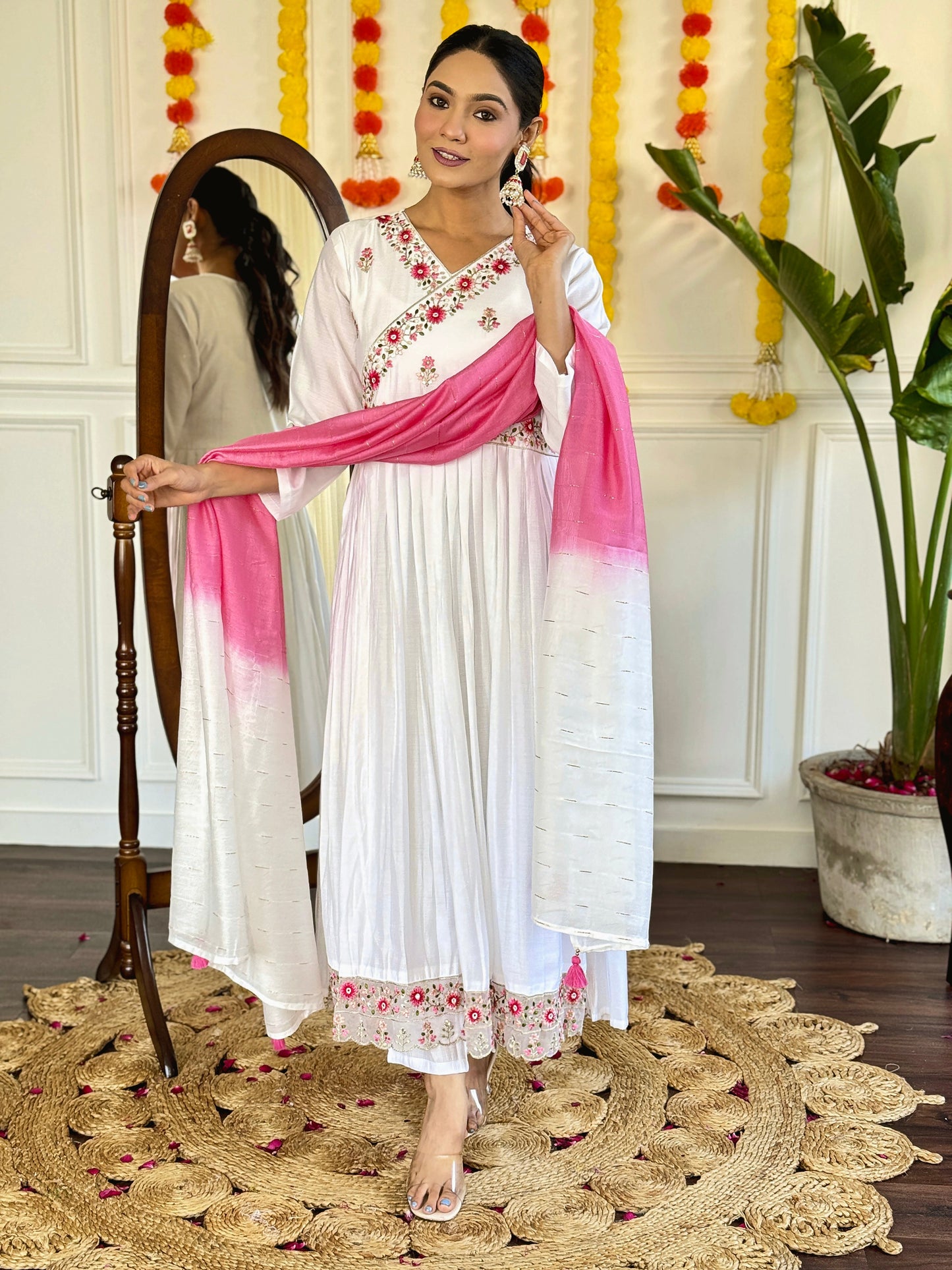 Grace meets elegance in this ethereal white Anarkali set, adorned with delicate floral embroidery and a stunning pink ombre dupatta